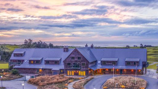 Sunset view of the Bandon Dunes Lodge and resort entrance surrounded by coastal dunes and natural landscaping.