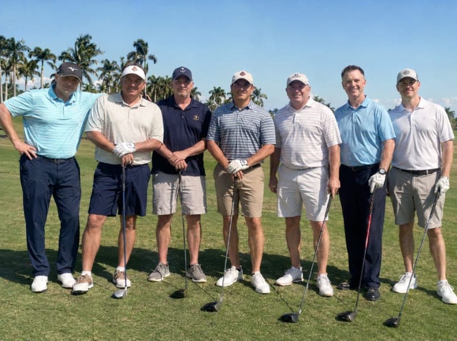 Seven golfers standing together on a golf course for an event or group BagCaddie shipment