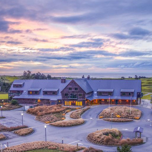Sunset view of the Bandon Dunes Lodge and resort entrance surrounded by coastal dunes and natural landscaping.
